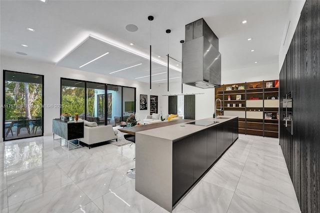 kitchen with a large island, modern cabinets, marble finish floor, black electric stovetop, and a sink