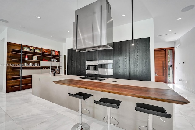 kitchen featuring modern cabinets, oven, black electric stovetop, ventilation hood, and a kitchen bar