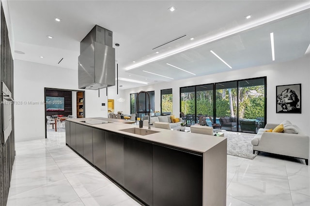 kitchen with open floor plan, marble finish floor, modern cabinets, and a large island with sink