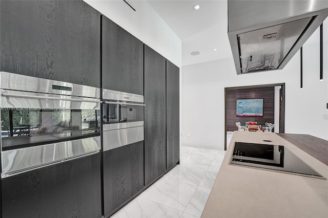 kitchen with marble finish floor and dark cabinets