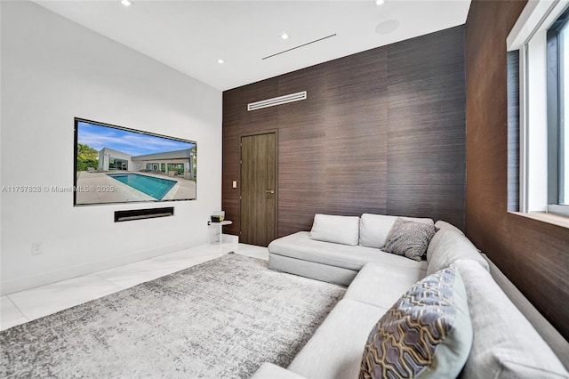 living area with marble finish floor, recessed lighting, an accent wall, and baseboards