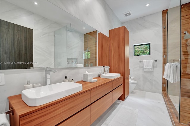 bathroom featuring tile walls, visible vents, toilet, an enclosed shower, and a sink