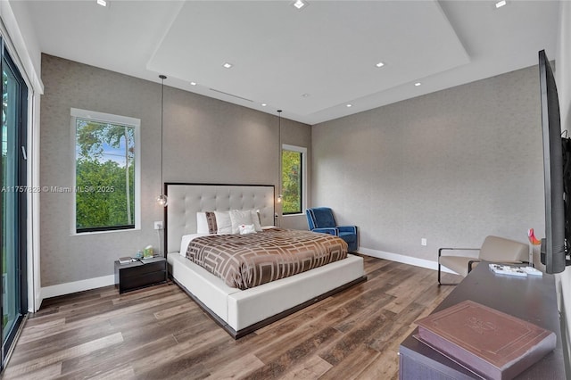 bedroom with baseboards, wood finished floors, and recessed lighting