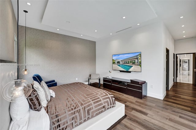 bedroom with baseboards, wood finished floors, and recessed lighting