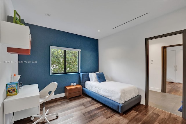 bedroom with baseboards, wood finished floors, and recessed lighting