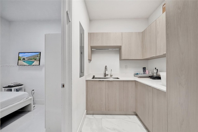 kitchen featuring light brown cabinets, a sink, light countertops, marble finish floor, and modern cabinets