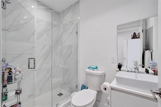 bathroom with toilet, a marble finish shower, and vanity