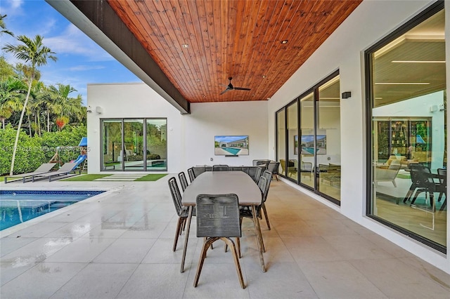 view of patio featuring outdoor dining area, a ceiling fan, and an outdoor pool