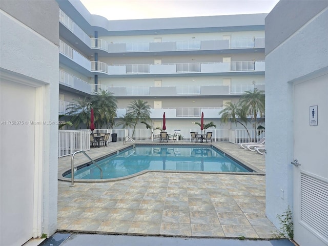 pool with fence and a patio