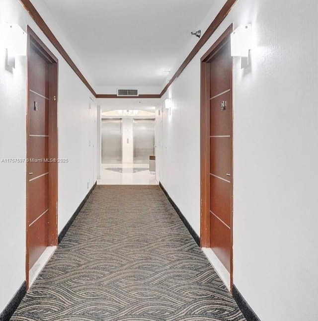 corridor featuring baseboards, visible vents, carpet flooring, and ornamental molding