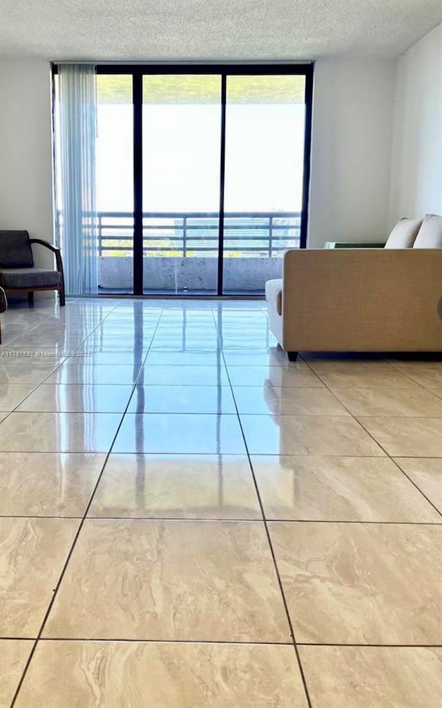 unfurnished living room featuring floor to ceiling windows, a textured ceiling, and light tile patterned floors