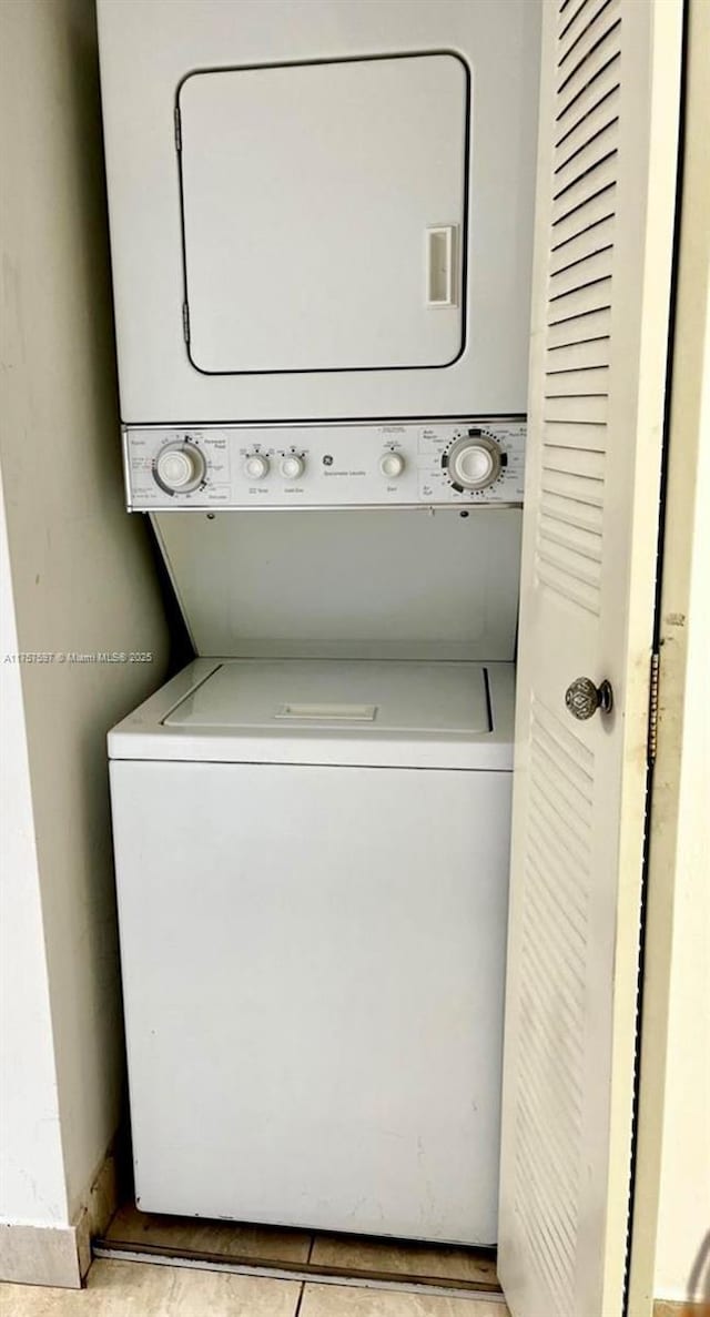 laundry room featuring stacked washer / drying machine and laundry area