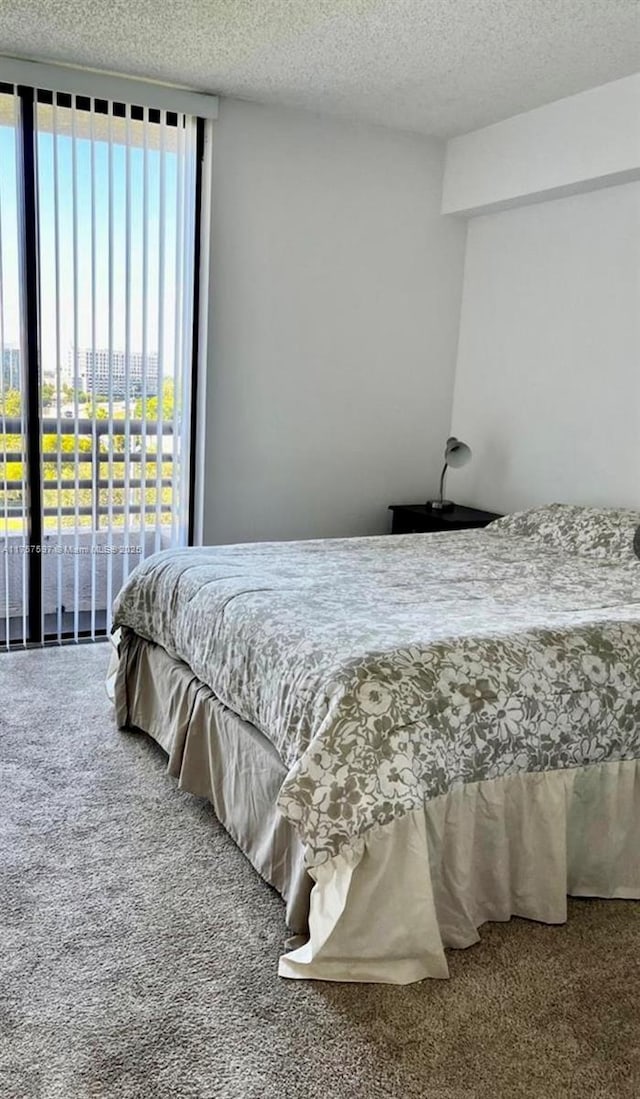 carpeted bedroom featuring access to outside and a textured ceiling