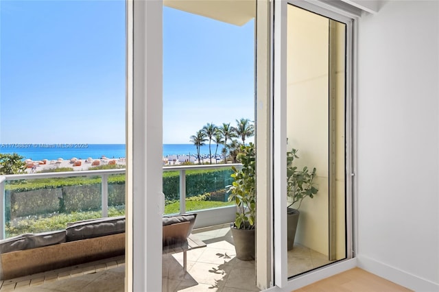 doorway to outside featuring a water view and baseboards