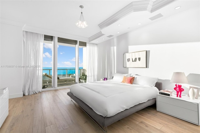 bedroom featuring access to exterior, light wood-type flooring, ornamental molding, and a wall of windows