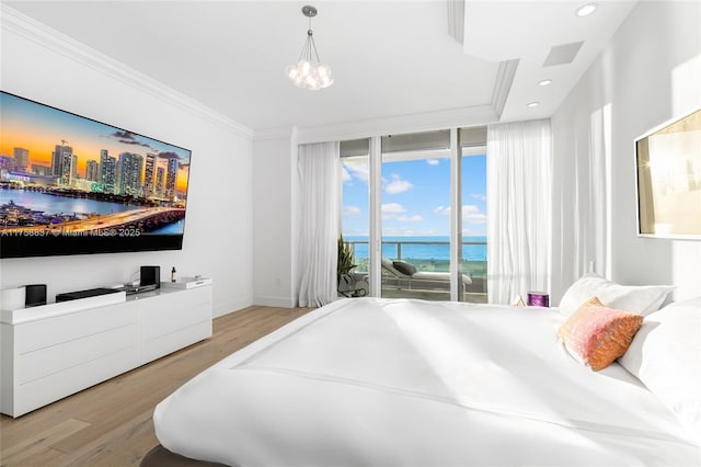 bedroom with wood finished floors, a water view, access to exterior, expansive windows, and crown molding