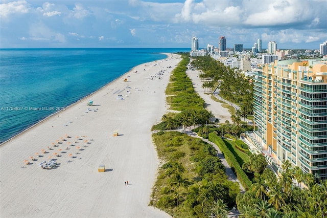 drone / aerial view featuring a water view, a view of city, and a view of the beach