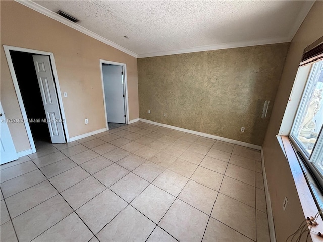 spare room with visible vents, lofted ceiling, light tile patterned flooring, ornamental molding, and a textured ceiling