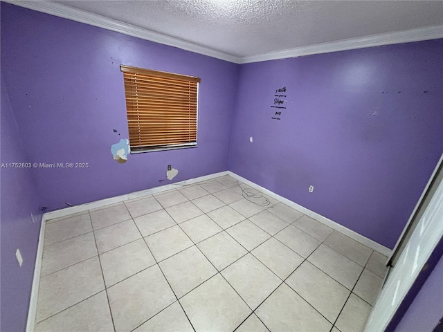 spare room with crown molding, baseboards, and a textured ceiling