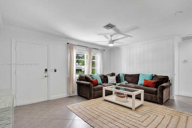 living area with a ceiling fan, visible vents, crown molding, and light tile patterned flooring