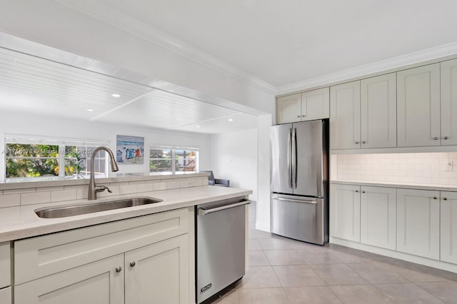 kitchen featuring light tile patterned flooring, stainless steel appliances, a sink, light countertops, and decorative backsplash