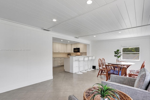 living room with recessed lighting, visible vents, beamed ceiling, and light tile patterned floors