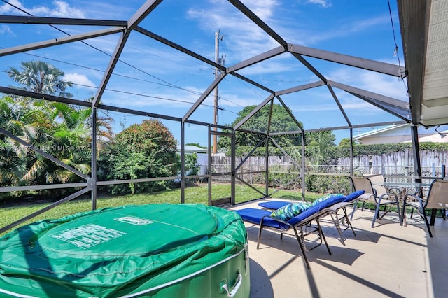 view of patio featuring glass enclosure and a fenced backyard