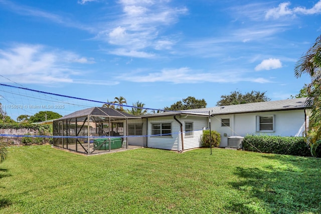 rear view of property with glass enclosure, a yard, a swimming pool, and cooling unit