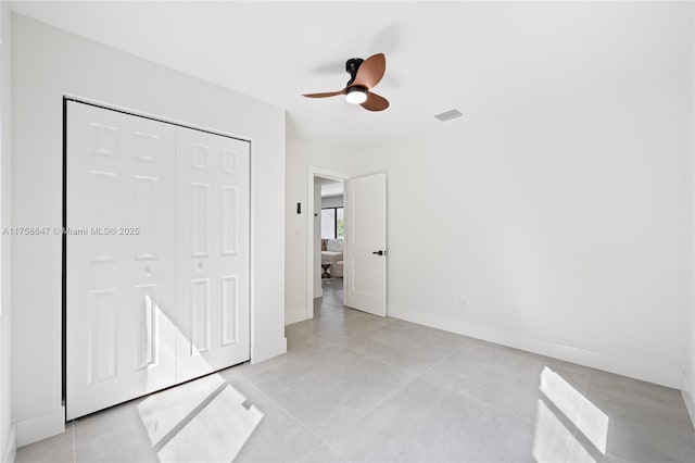 unfurnished bedroom with baseboards, visible vents, a ceiling fan, concrete flooring, and a closet