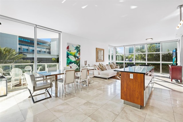 kitchen with dark countertops, open floor plan, floor to ceiling windows, and a kitchen island