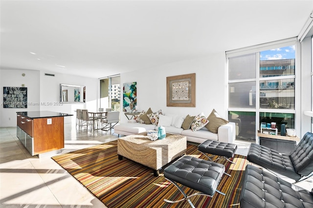 living area featuring expansive windows and light tile patterned floors