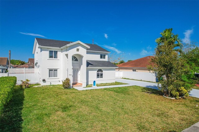 back of house with fence, a lawn, and stucco siding