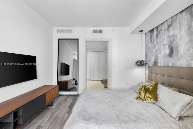 bedroom with visible vents and wood finished floors