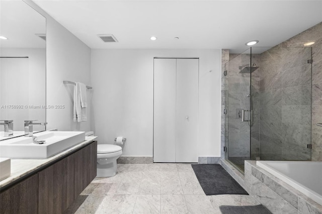 bathroom featuring toilet, a stall shower, a sink, and visible vents