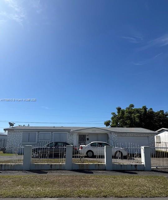 back of house featuring a fenced front yard and a gate