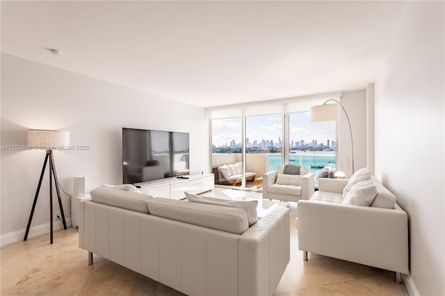 living area featuring a wall of windows and baseboards