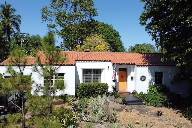 mediterranean / spanish house with stucco siding and a tiled roof