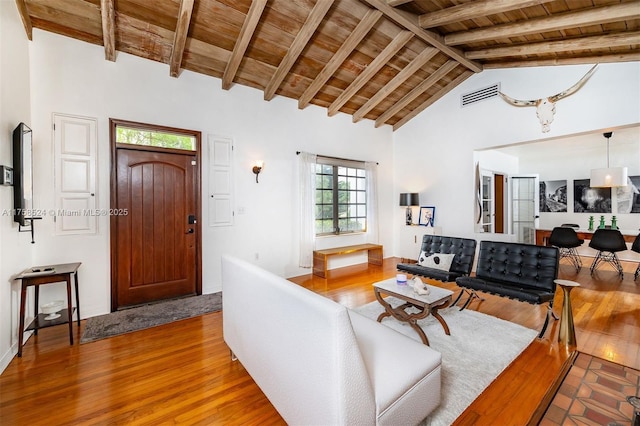 living room featuring visible vents, beamed ceiling, wooden ceiling, and light wood-style floors