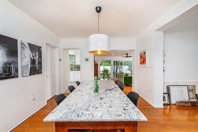 dining room featuring light wood-style flooring and baseboards