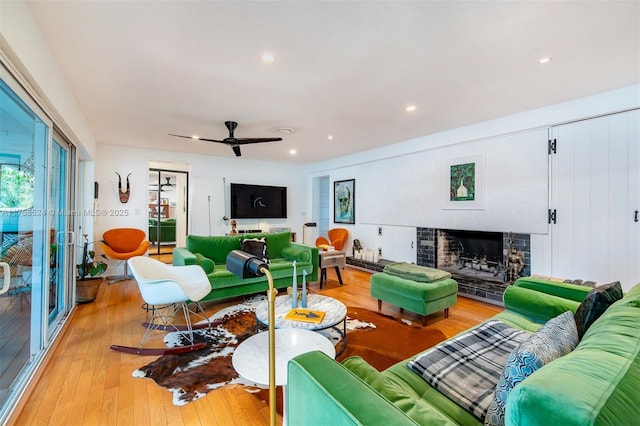 living room featuring recessed lighting, a ceiling fan, light wood-style floors, and a fireplace