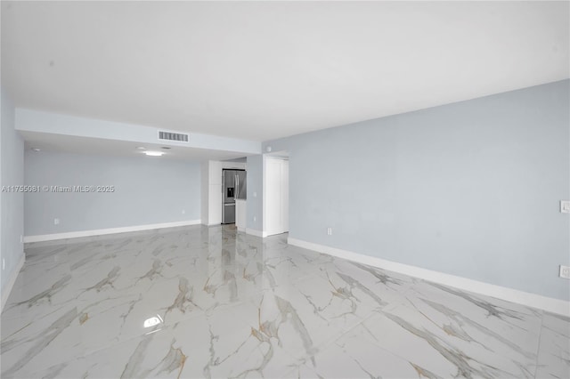 unfurnished room with marble finish floor, visible vents, and baseboards