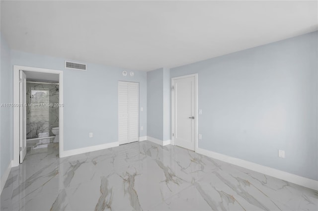 unfurnished bedroom featuring marble finish floor, ensuite bath, visible vents, and baseboards