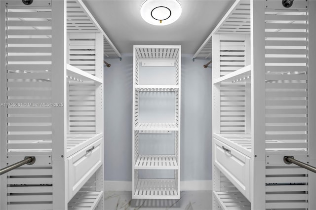 walk in closet with marble finish floor