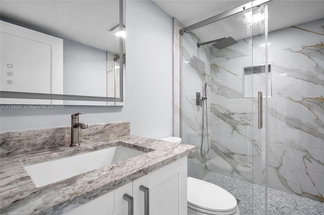 full bath featuring toilet, a marble finish shower, and vanity