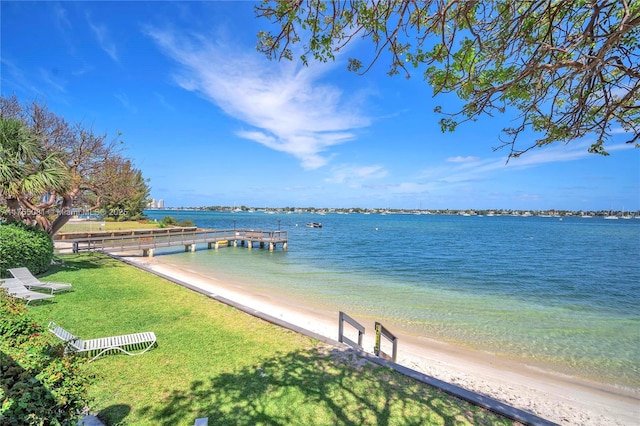 dock area featuring a water view and a lawn