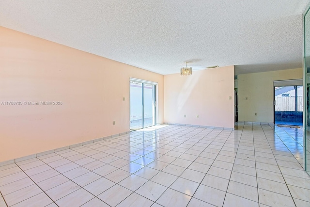 empty room with visible vents, a textured ceiling, and light tile patterned flooring