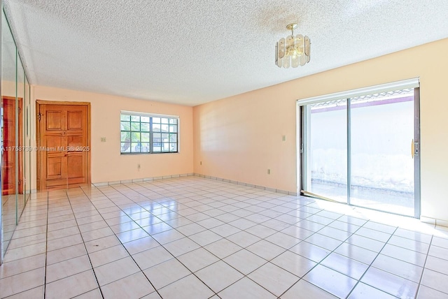 unfurnished room featuring light tile patterned flooring, a textured ceiling, and baseboards