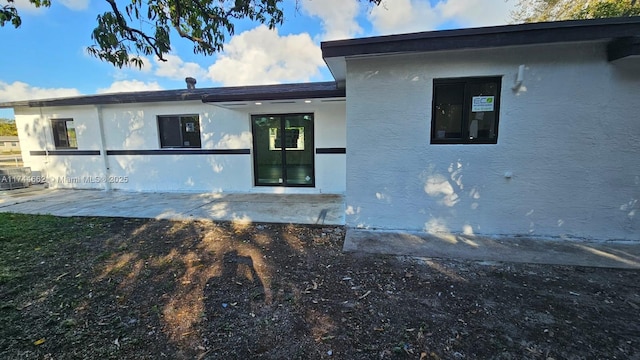 exterior space featuring a patio area and stucco siding