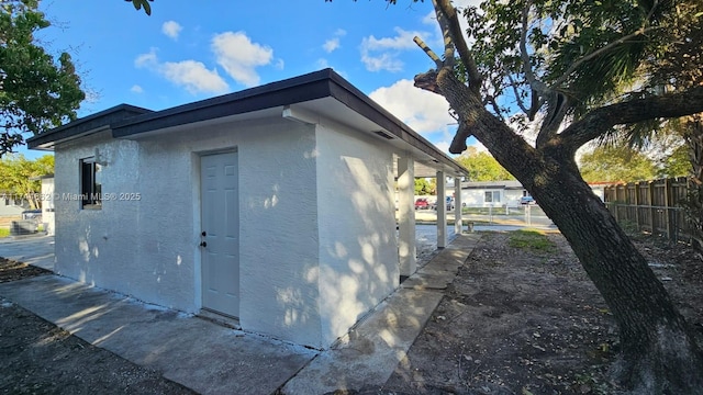 view of side of home with fence and stucco siding