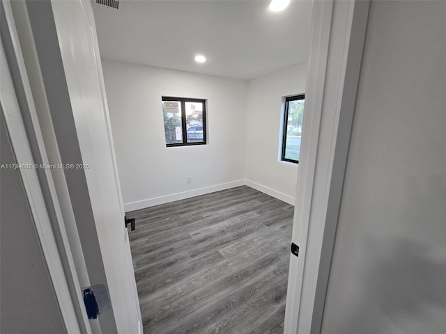 unfurnished room with recessed lighting, dark wood finished floors, and baseboards